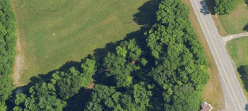 Unzoned Wooded Acreage with Barns